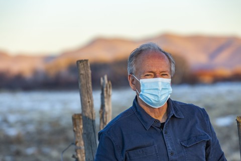 Outdoor portrait of senior man wearing COVID protective mask