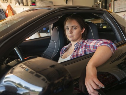 Woman sitting in car in garage