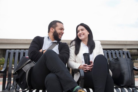 Young couple sitting on bench on platform