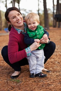 Laughing mother tickling son in park