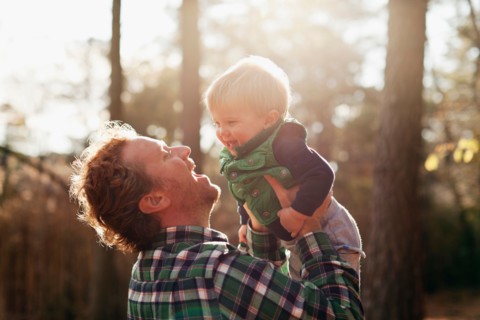 Father carrying son in park