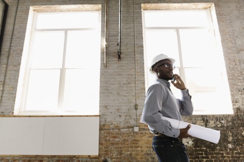 Young interior designer looking at new office space