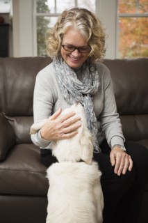 Senior woman with dog in living room