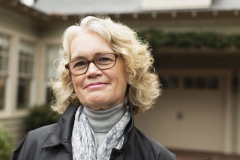 Portrait of happy senior woman outside house
