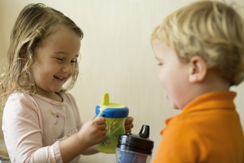 Male and female toddler friends having a drink