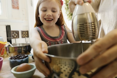 Girl giving mother a helping hand in kitchen