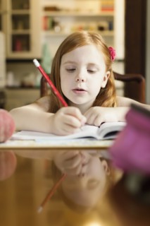 Girl doing school homework at dining room table
