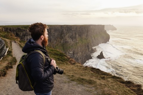 Mid adult man on The Cliffs of Moher with camera