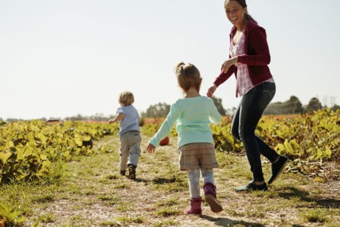 Mother with two children in pumpkin field