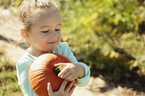 Girl carrying pumpkin
