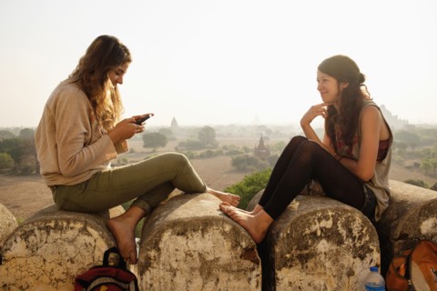 Women relaxing on stone wall