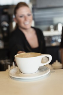 Coffee shop barista serving coffee