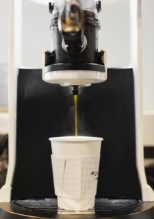Coffee flowing from coffee machine in coffee shop