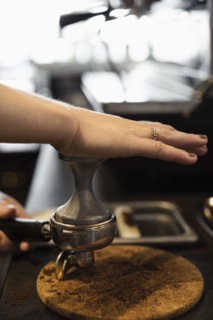 Coffee shop barista removing coffee grounds