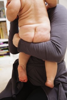 Mother holding nude baby girl