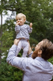Father holding baby girl in air