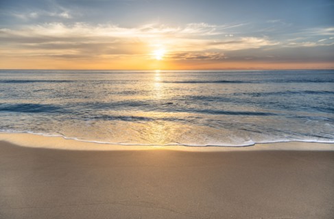 Sun rising above sea