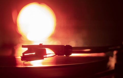 Close-up of a record player needle on record in orange light