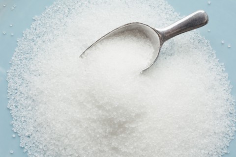 Studio shot of heap of sugar and scoop
