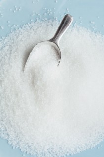 Studio shot of heap of sugar and scoop