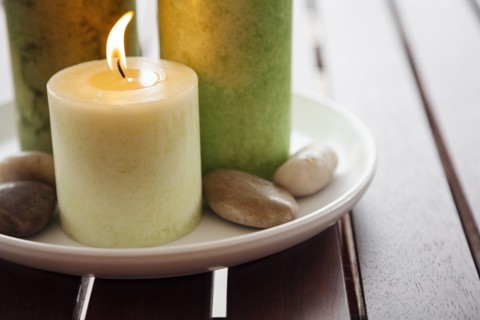 Close-up of candles and stones on plate