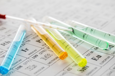 Test tubes with liquids and pipette on periodic table