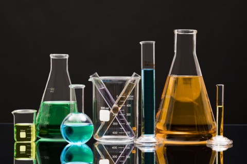 Laboratory glassware with liquids against black background