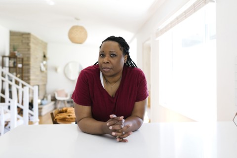 Portrait of woman leaning against kitchen counter