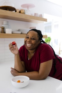 Smiling woman eating red peppers