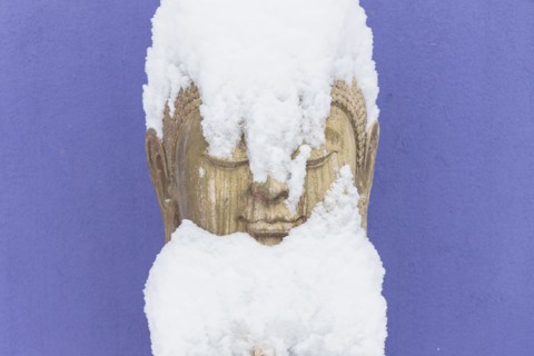 Snow covering stone Buddha statue