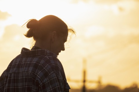 Silhouette of woman against sunset sky