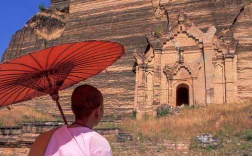 Buddhist nun in front of old Buddhist temple ruined by earthquake