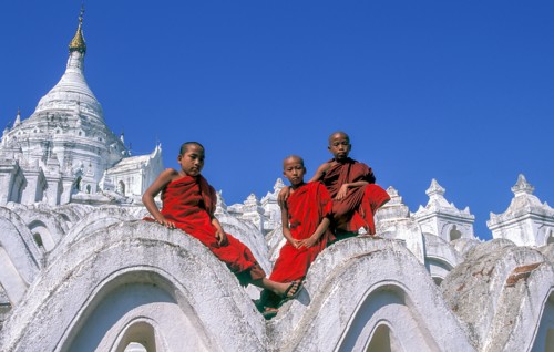Buddhist monks sitting on white arches of Hsinbyume Pagoda