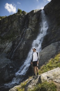 Man standing near Sofiyskiye Vodopady waterfall in Caucasus Mountains