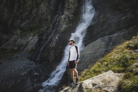 Man standing near Sofiyskiye Vodopady waterfall in Caucasus Mountains