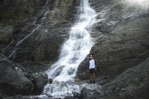 Man standing near Sofiyskiye Vodopady waterfall in Caucasus Mountains