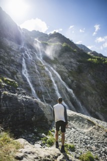 Man standing near Sofiyskiye Vodopady waterfall in Caucasus Mountains