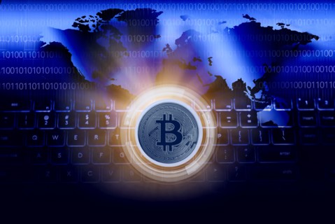 Bitcoin against World map and computer keyboard