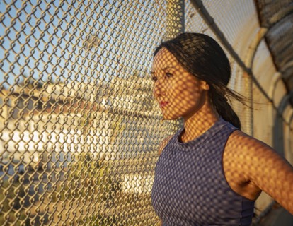 Athlete woman resting at fence