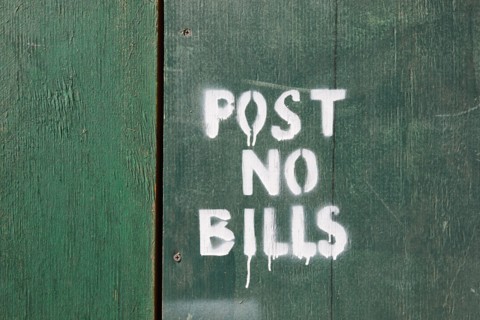 Post no bills on green wooden fence