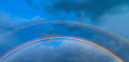 Double rainbow against stormy sky