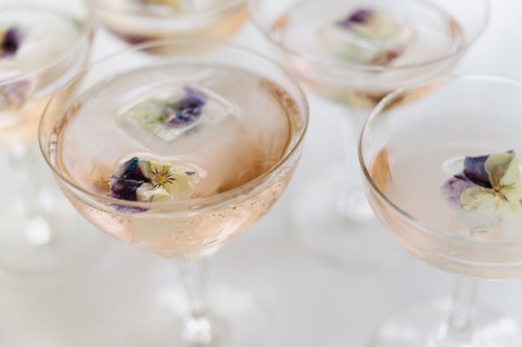Sparkling rose wine with edible flower garnish