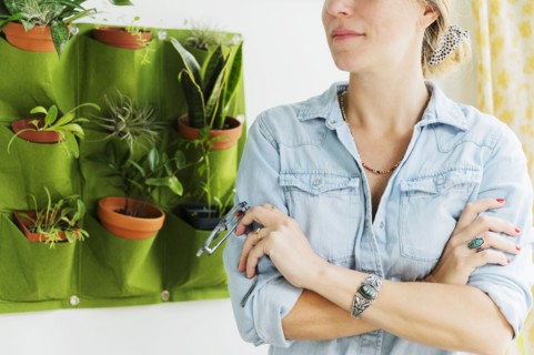 Woman standing by vertical garden