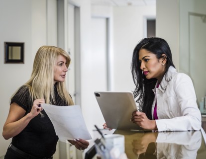 Doctor talking with patient at reception desk