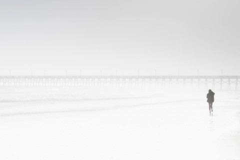Usa, North Carolina, Surf City, Woman walking on misty beach