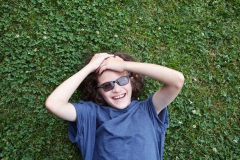 Boy lying in grass and laughing