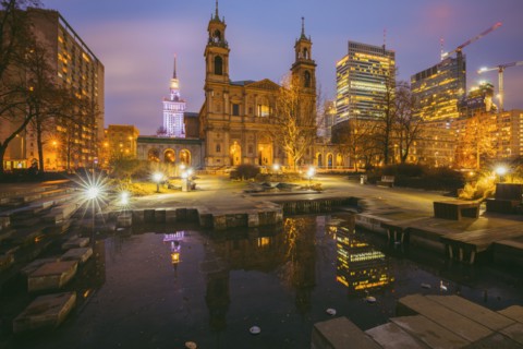 Poland, Masovia, Warsaw, Church and illuminated city skyscrapers reflecting in pond at night