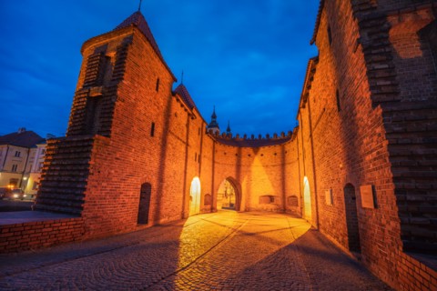 Poland, Masovia, Warsaw, Old City walls and barbican illuminated at night