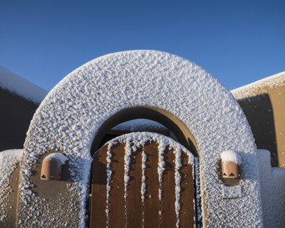 Usa, New Mexico, Santa Fe, Gate to Adobe style house covered with snow in winter
