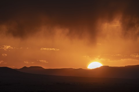 Usa, New Mexico, Santa Fe, El Dorado, Sun setting over landscape with clouds